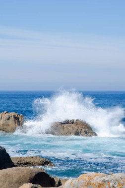 Dramatik okyanus dalgaları, güneşli bir günde engebeli kayalarla çarpışır ve kıyı şeridinde güçlü sıçramalar ve doğal bir enerji hissi yaratır. Doğa temaları için mükemmel.