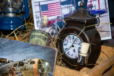 Katı ahşaptan yapılmış, eski bir viskiyle birlikte ahşap bir kutunun içinde eski bir saat. Amerikan havacılığının bazı eski fotoğraflarının arka planında. Retro otomobil fuarı, Romanya, Iasi 2020