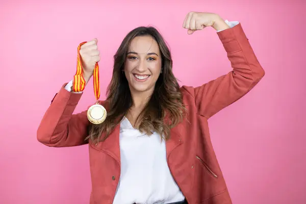 여자는 자랑스럽게 근육을 보여주는 메달을 배경에 캐주얼 재킷을 스톡 사진