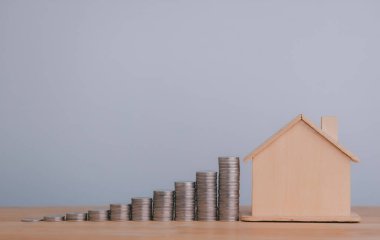 Home model and stacking money coins on wooden table, saving money wealth and financial concept, Business, finance, investment, Financial planning for future.