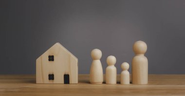 Concept Warm family prototype with happy wooden doll family with big house family caring. Child sponsorship, mental health, Domestic violence, social distancing. Copy space