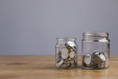 Save money concept for Finance Banking Business Idea with money in a glass jar on wooden table with filter effect retro vintage style. Investments, Funds, Bonds, Dividends and Interest.