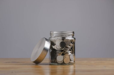 Filter effect retro vintage style for money in the glass jar on wooden table. Save money concept for Finance Banking Business Ideas, Investments, Funds, Bonds, Dividends and Interest.