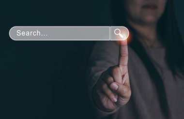 İş kadını, ilgilendikleri şeyi bulmak için internete tıklıyor ve İnternet Bilgi Ağı Arama Tarayıcı 'nın bilgisayardaki dokunmatik ekranında arama yapıyor. Boşluğu kopyala.