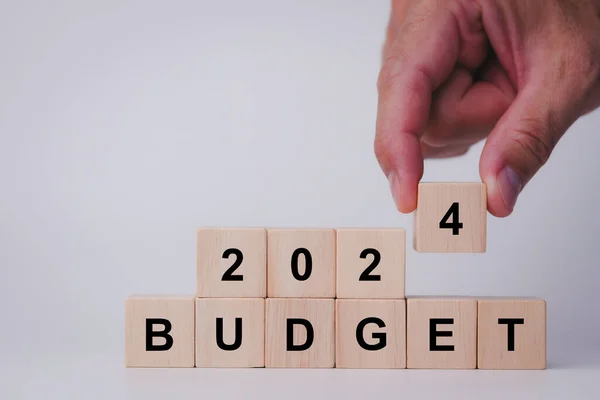 2024 Budget planning and allocation concept. Hand putting wooden cubes form the expression \
