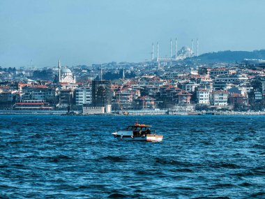 Şehrin arka planında, suda bir tekne.