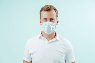 Klinikte maske takan açık mavi arka planda bir doktor. Sağlıklı konsept