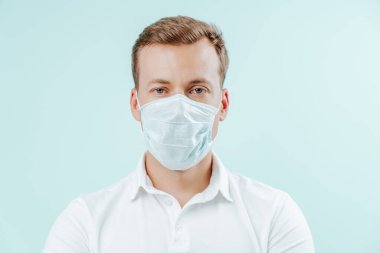 Klinikte maske takan açık mavi arka planda bir doktor. Sağlıklı konsept