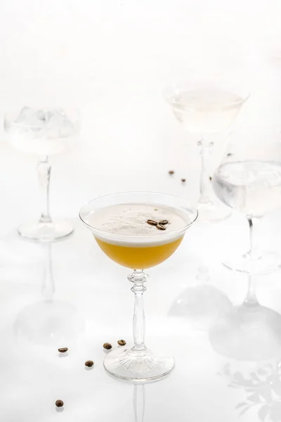 Cocktail mix in glass on white background with alcohol, coffee beans peel foam martini espresso.