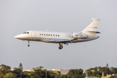 Luqa, Malta - 23 Haziran 2023: Air Alsie Dassault Falcon 2000LX (Reg. : OY-MGO) gece yarısı ışıklarına iniyor.