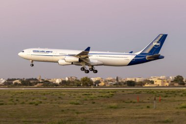 Luqa, Malta - 30 Kasım 2023: Universal Sky Carrier (USC) Airbus A340-313 (REG: D-AUSC) tamamen karanlık çökmeden iniş yaptı.