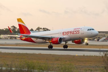 Luqa, Malta 21 Haziran 2016: Iberia Express Airbus A320 (REG: EC-LYM) gün batımından hemen sonra yeni İberya Ekspres üniformasını giyerek geldi.