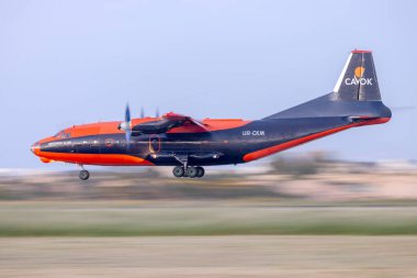 Luqa, Malta - 27 Mart 2024: Cavok Air Antonov An-12BP (REG: UR-CKM), hava kararmadan hemen önce indi.