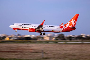 Luqa, Malta - 2 Nisan 2024: SkyUp Airlines Boeing 737-8KN (WL) (REG: 9H-SAU) günün son loş ışığına iniyor.