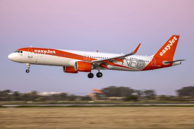 Luqa, Malta - 2 Nisan 2024: EasyJet Airbus A321-251NX (REG: G-UZMA) gün batımından sonra iniş.