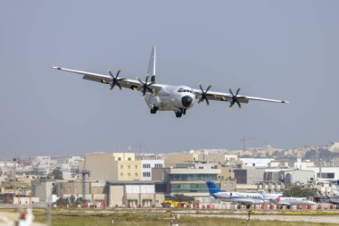 Luqa, Malta - April 13, 2024: Pallas Aviation Lockheed Martin LM-100J Hercules (L-382) (Reg.: N67AU) landing in crosswind runway 13. clipart