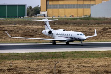 Luqa, Malta - May 17, 2024: Qatar Executive Gulfstream G650ER (Reg: A7-CGM) turning mid runway for take off. clipart
