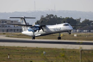 Luqa, Malta - June 4, 2024: Universal Air Bombardier DHC-8-402 Q400 (REG: 9H-MMW), 2nd Dash 8 in operation with Universal Air. clipart