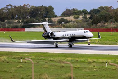 Luqa, Malta - 3 Aralık 2024: Avcon Jet Gulfstream Havacılık G-V Gulfstream V (REG: OE-IIS) bulutlu bir sabah 31. piste iniş yaptı.