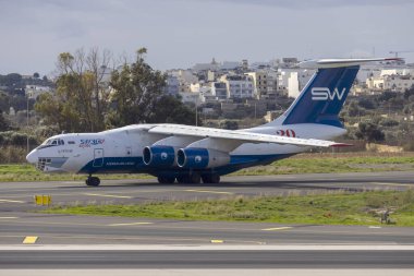 Luqa, Malta - January 2, 2025: Silk Way Airlines Ilyushin Il-76TD-90SW (Reg: 4K-AZ101) departing Malta after arriving after sunset on the last day of 2024. clipart