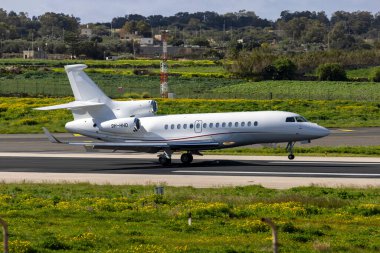 Luqa, Malta - 8 Mart 2025: ElitAvia Malta Dassault Falcon 7X (REG: 9H-HHHD) yeni kayıtlı, iniş pisti 31.