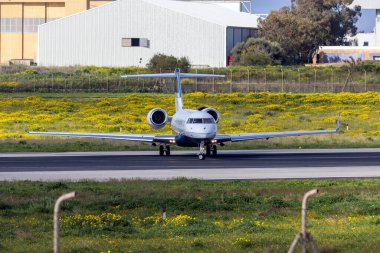 Luqa, Malta - 8 Mart 2025: Bombardier Global 5000 (BD-700-1A11) (Reg. : VP-CYJ) kalkış için orta piste dönüyor.