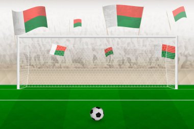 Madagaskar futbol takımı taraftarları Madagaskar bayraklarıyla stadyumda tezahürat yapıyor, futbol maçında penaltı vuruşu kavramı.