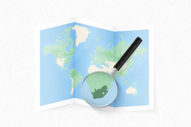 Enlarge South Africa with a magnifying glass on a folded map of the world.