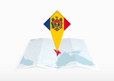 Moldova katlanmış bir kağıt haritada ve Moldova bayrağıyla tutturulmuş konum işaretleyicisinde resmediliyor.