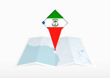Ekvator Ginesi katlanmış bir kağıt haritada ve Ekvator Ginesi bayrağıyla tutturulmuş konum işaretleyicisinde resmedilmiştir..