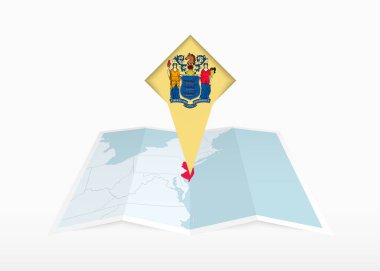 New Jersey katlanmış bir kağıt haritada ve New Jersey bayrağıyla işaretlenmiş..