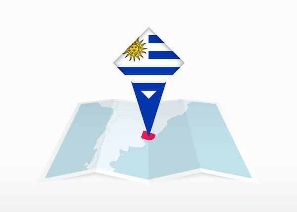 乌拉圭被描绘在一张折叠的纸质地图和印有乌拉圭国旗的别针定位标识上 — 图库矢量图片