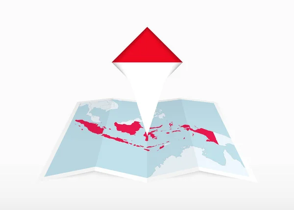 印度尼西亚被描绘在一张折叠的纸质地图上 并被钉上带有印度尼西亚国旗的位置标识 — 图库矢量图片