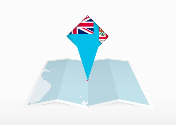 斐济被描绘在一张折叠的纸质地图上 并被钉上印有斐济国旗的位置标识 — 图库矢量图片