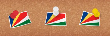 Seyşeller bayrağı mantar panoya asılmış, Seyşeller bayrağının üç versiyonu..