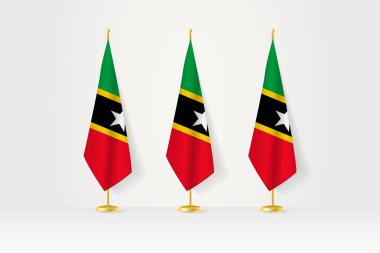 Üç Saint Kitts ve Nevis bayrakları altın bir standın üzerinde, basın toplantılarının ve diğer toplantıların resimleri..
