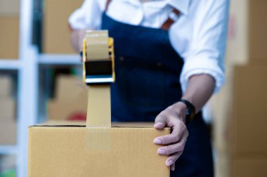 Çevrimiçi iş teslimatı, çevrimiçi satış, paket teslimatı, e-ticaret için maskeleme bandı olan genç bir kadın..