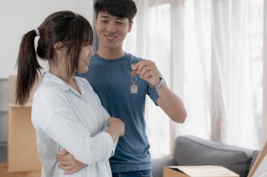 Büyük kutuları olan genç çift yeni bir eve taşınıyor, çift için yeni bir daire, genç adam ve kadın kutuları taşımaya yardım ediyorlar ve yeni ev için eşyaları düzenliyorlar, taşınıyorlar..