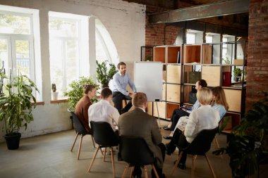 Yeni iş projesinin tartışması. Genç erkekler ve kadınlar. Ofisteki iş arkadaşları açık alanda, kapalı mekanda buluşuyorlar. Finans, eğitim, beyin fırtınası, iş. ve başlangıç konsepti