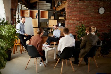 Yeni iş projesinin tartışması. Genç erkekler ve kadınlar. Ofisteki iş arkadaşları açık alanda, kapalı mekanda buluşuyorlar. Finans, eğitim, beyin fırtınası, iş. ve başlangıç konsepti