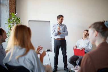 Projeler, planlar ve başarılar. Gençler konuşuyor, çalışıyor, iş arkadaşlarıyla sorun ve fikirleri tartışıyor, iş arkadaşları toplantı odasında. Mesleki meslek, kariyer, motivasyon