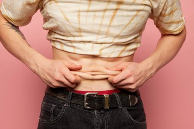 Karnını ve karnını gösteren bir adam görüntüsü. Erkek vücudunun bir parçasını kapat. Diyet, spor, spor, sağlıklı yaşam tarzı, vücut pozitifliği kavramı. Liposuction ve plastik cerrahi