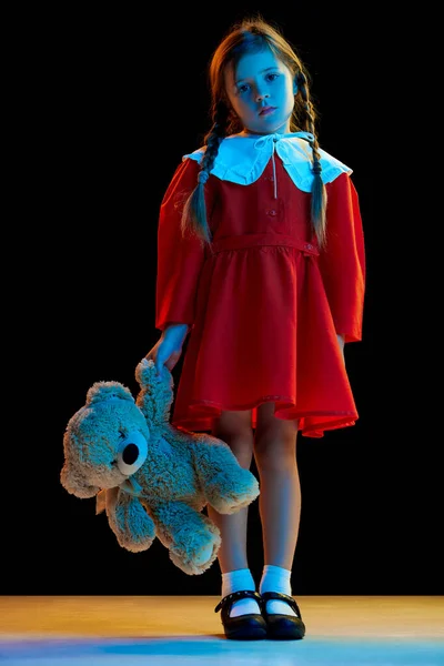 Печаль Маленькая Девочка Косичками Красном Праздничном Платье Стоящая Плюшевым Мишкой — стоковое фото