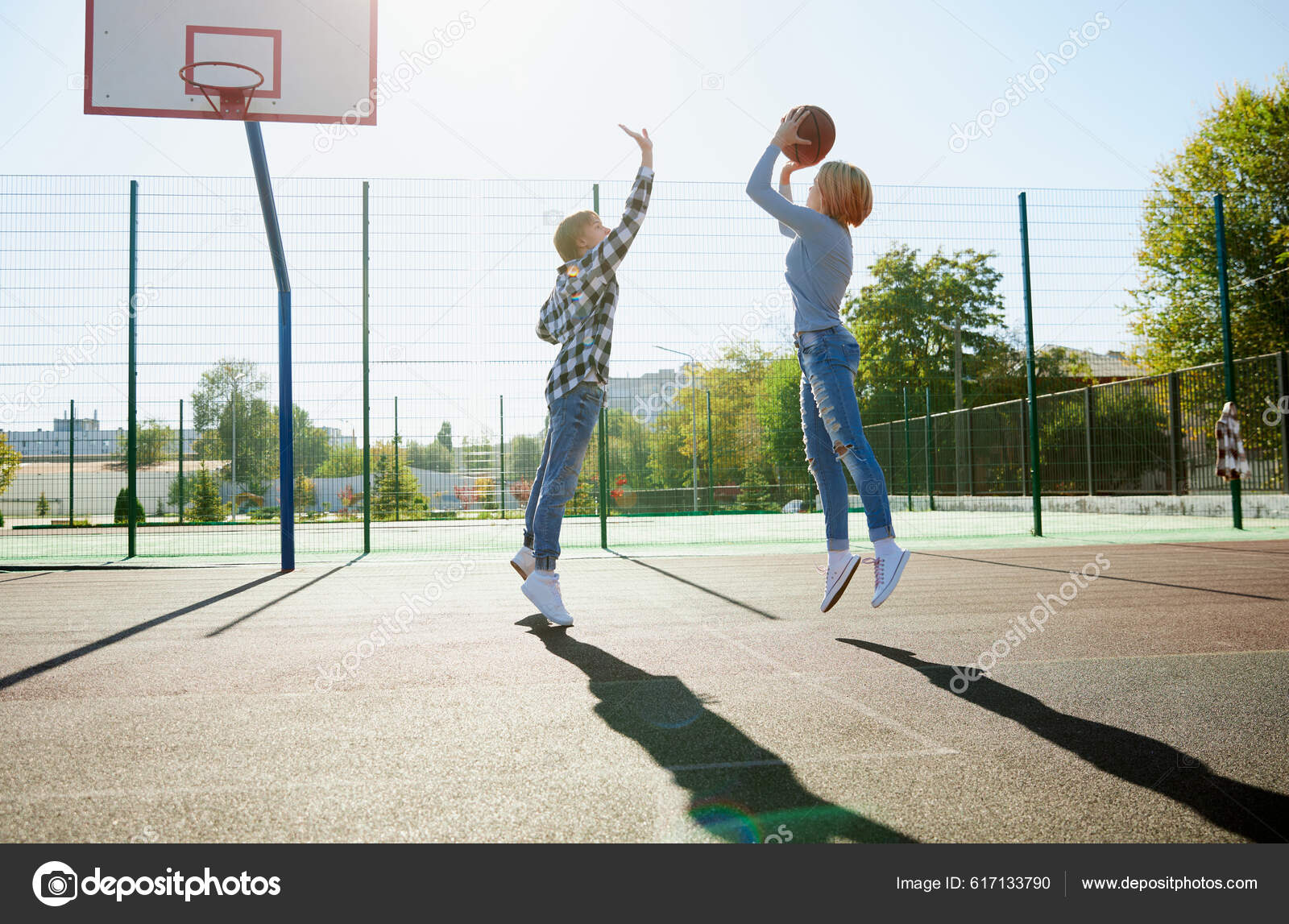 Grupo de amigos jogando basquete em uma quadra pública ao ar livre