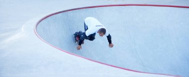 Hız, enerji ve güç. Bir adam, erkek patenci modern paten parkında paten eğitimi alıyor, açık havada. Hareket, hareket, beceri ve zorluklar. Farklı numaralar yapıyor. Amatör sporlar