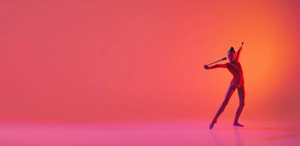 ダンスだ 運動中の若い柔軟な10代の少女リズム体操 ネオンの光のピンクの背景に隔離されたアクション スポーツ 美しさ 柔軟性 アクティブなライフスタイル 個々の演奏 — ストック写真