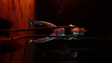 Enerjik, kendini işine adamış kadın sporcu spor salonunda savaş halatlarıyla antrenman yapıyor. Güç ve kardiyo çalışması. Enerji, güç, spor ve sağlıklı yaşam tarzı kavramı. Fitness koçu hareket halinde