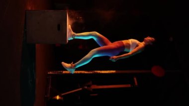 Atlıyor. Spor giyinen genç bir kadın spor salonunda neon ışık filtresiyle antrenman yapıyor. Güç ve kardiyo çalışması. Enerji, güç, spor ve sağlıklı yaşam tarzı kavramı. 4K görüntü