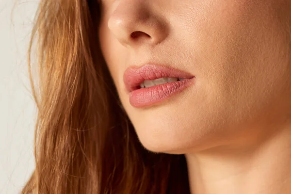 Cropped close-up image of female face, nose an lips. Lip augmentation and permanent cosmetics, permanent makeup. Concept of beauty, skin care, health, plastic surgery, facial treatment, cosmetology