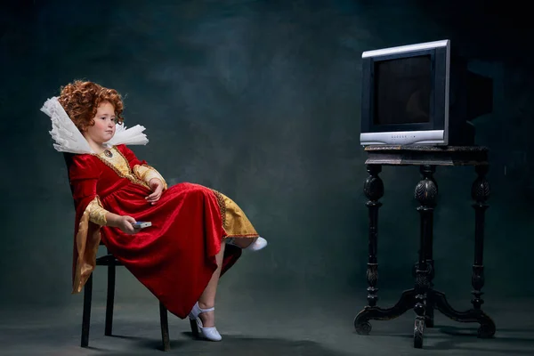 Mała Rudowłosa Dziewczynka Obraz Królewskiej Osoby Siedzącej Przed Telewizorem Ciemnozielonym — Zdjęcie stockowe